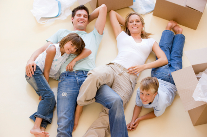 Father, Mother, son and daughter lying on the floor with boxes.